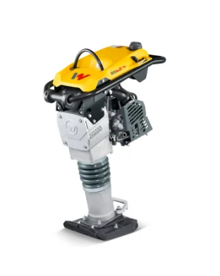 Compact yellow New West Equipment jumping-jack compactor with a black metal base plate, exposed coil spring and small gasoline engine.